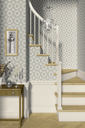 Elegant staircase with 'Timeless Floral Wreaths' wallpaper in muted sage-gray, featuring classic ivory laurel designs for a traditional look.