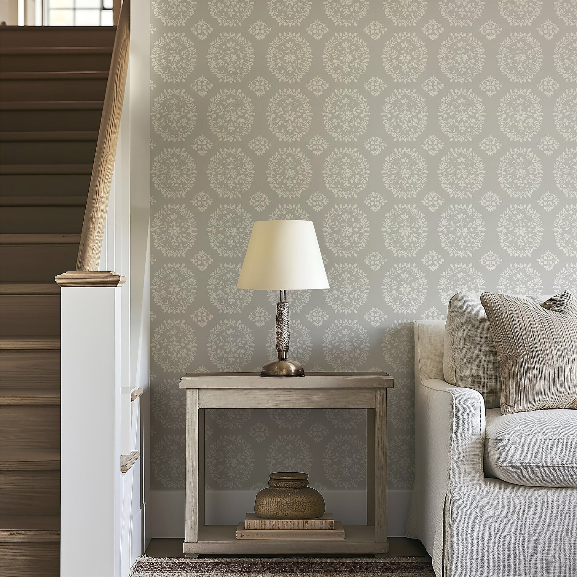 Elegant Floral Framework wallpaper with laurel wreaths in white and gray, creating a tranquil, traditional look in a cozy living space.