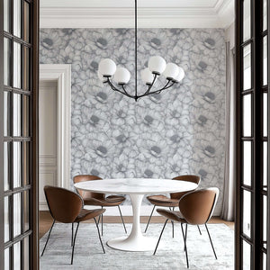 Monochrome floral wallpaper in a dining room with a modern chandelier and stylish furniture, highlighting botanical elegance.