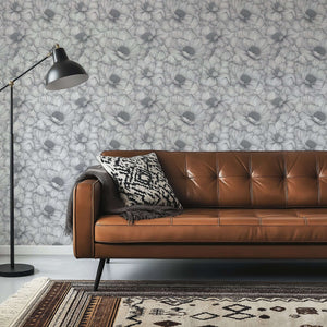 Graphite Garden Dance wallpaper with hand-inked floral pattern in monochrome tones, enhancing modern living room decor with organic texture.