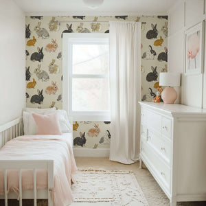 Enchanted Woodland Bunnies wallpaper with hand-drawn rabbits on a tan background in a nursery.