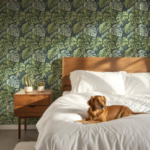 Tropical Canopy wallpaper featuring lush monstera leaves in a cozy bedroom with a golden retriever.