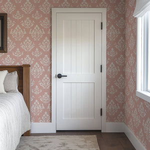 Timeless Pink Flora wallpaper in a cozy bedroom, featuring elegant floral laurels on a soft pink background.