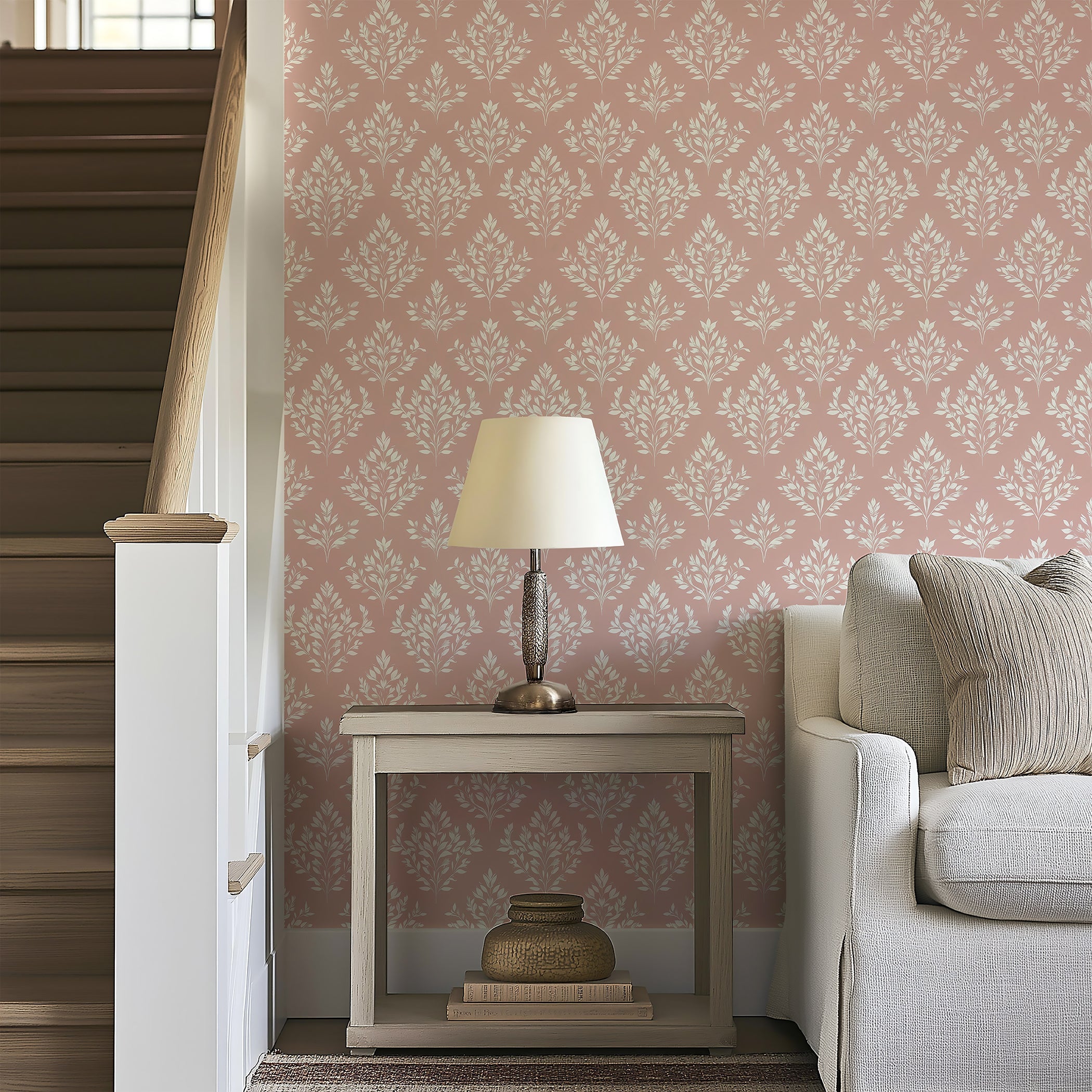 Elegant living space featuring Timeless Pink Flora wallpaper with floral laurels and a cozy lamp beside a neutral-toned sofa.