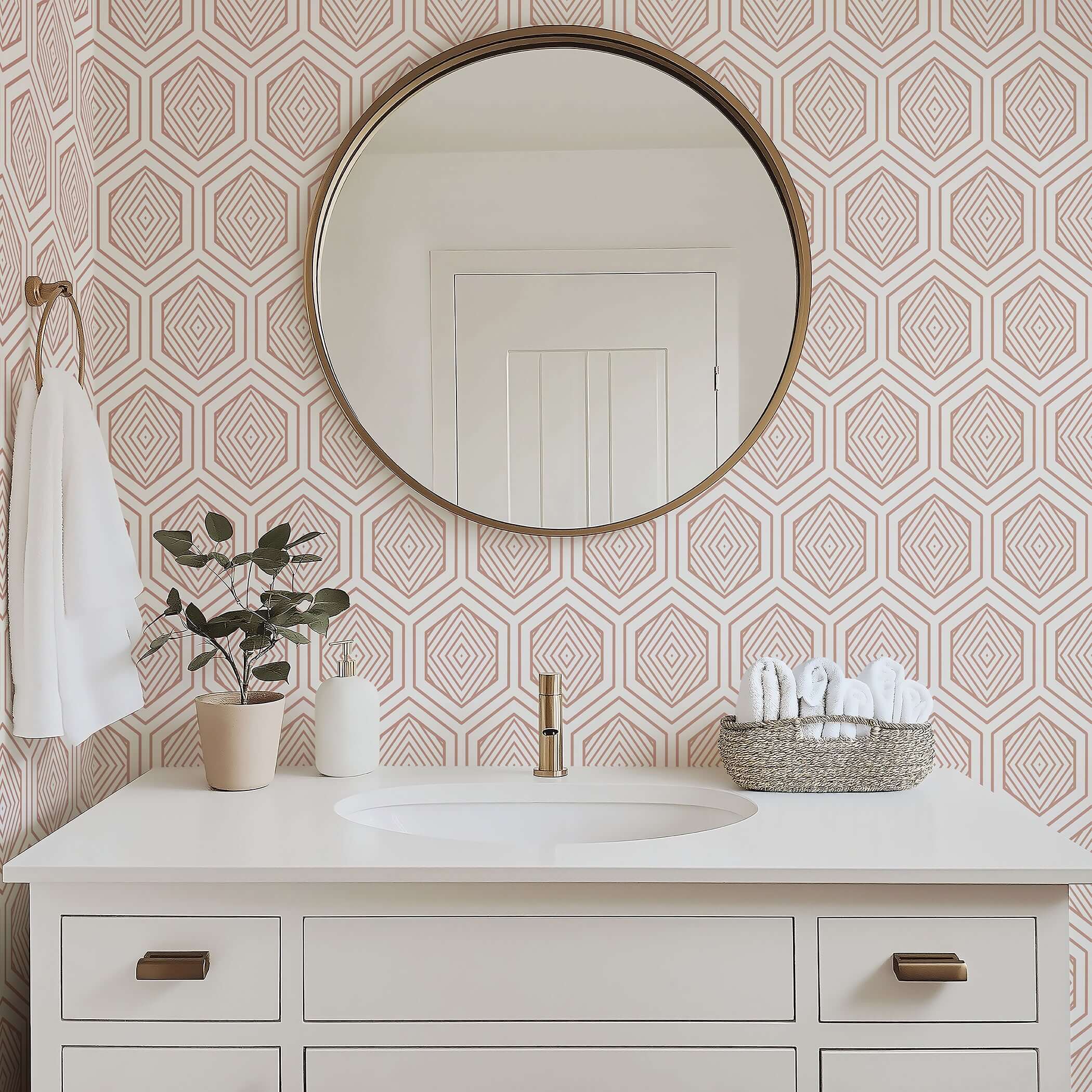 Geometric rose gold prism wallpaper in a modern bathroom with art deco style, white vanity, and round mirror.
