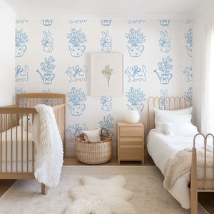 Modern nursery with Bow-Tied Kitten Bliss wallpaper featuring kittens, flowers, teapots, and a cozy contemporary setting.