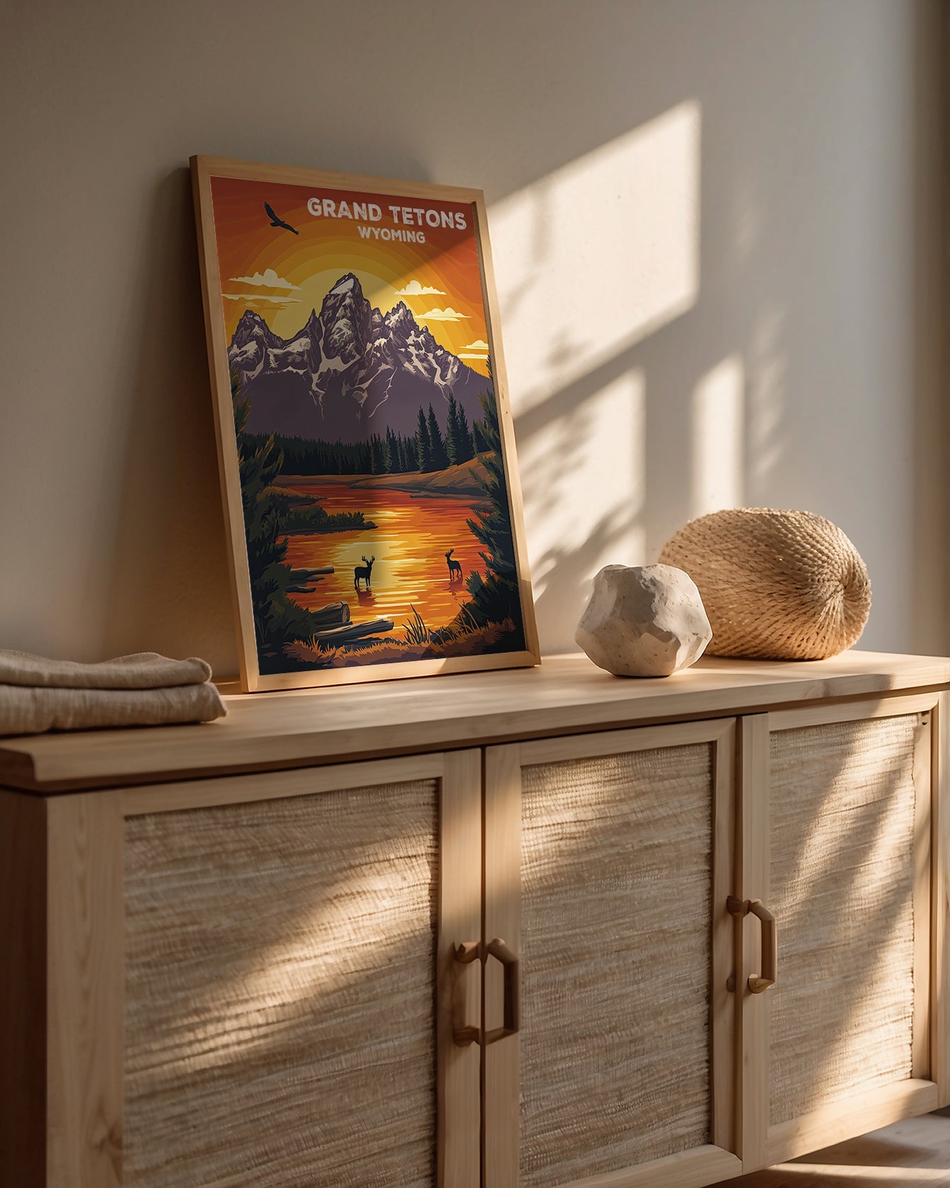 Vintage travel poster featuring Grand Tetons at sunset, showcasing mountains and serene waters in Wyoming.