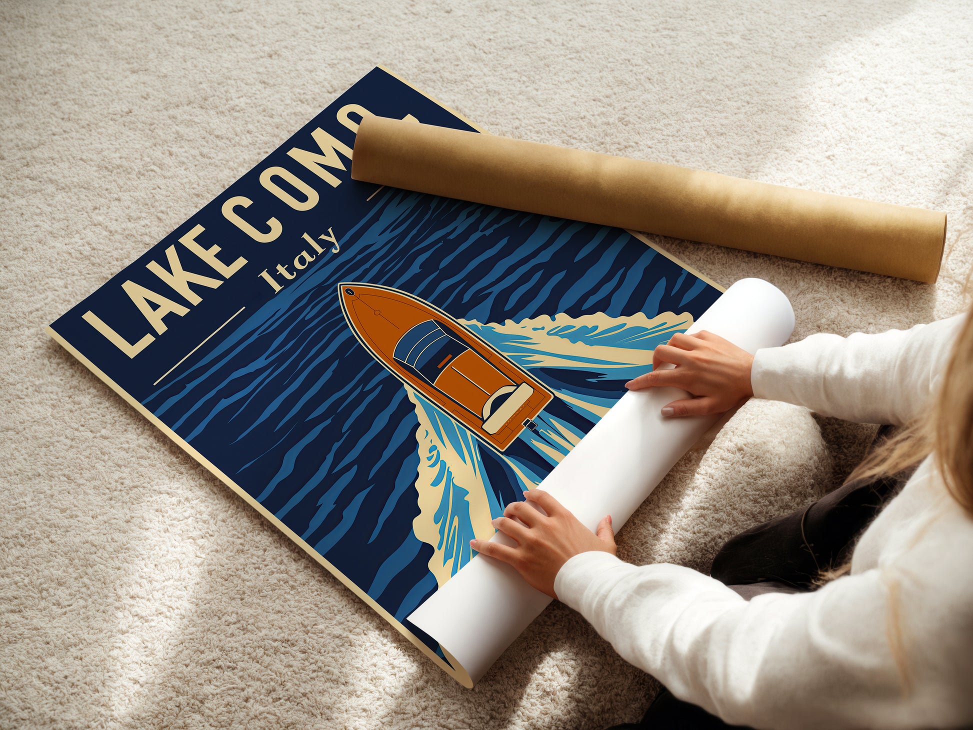 Person unrolling a vintage travel poster of Lake Como, Italy with a classic boat in deep blue waters.