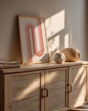 Sunset Stripes wall art print showcasing Bauhaus design with warm coral and blush lines in a modern interior.
