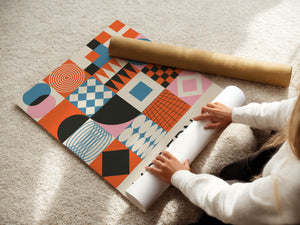 Woman unrolling a colorful Bauhaus-inspired art print featuring geometric shapes and bold colors on a soft rug.