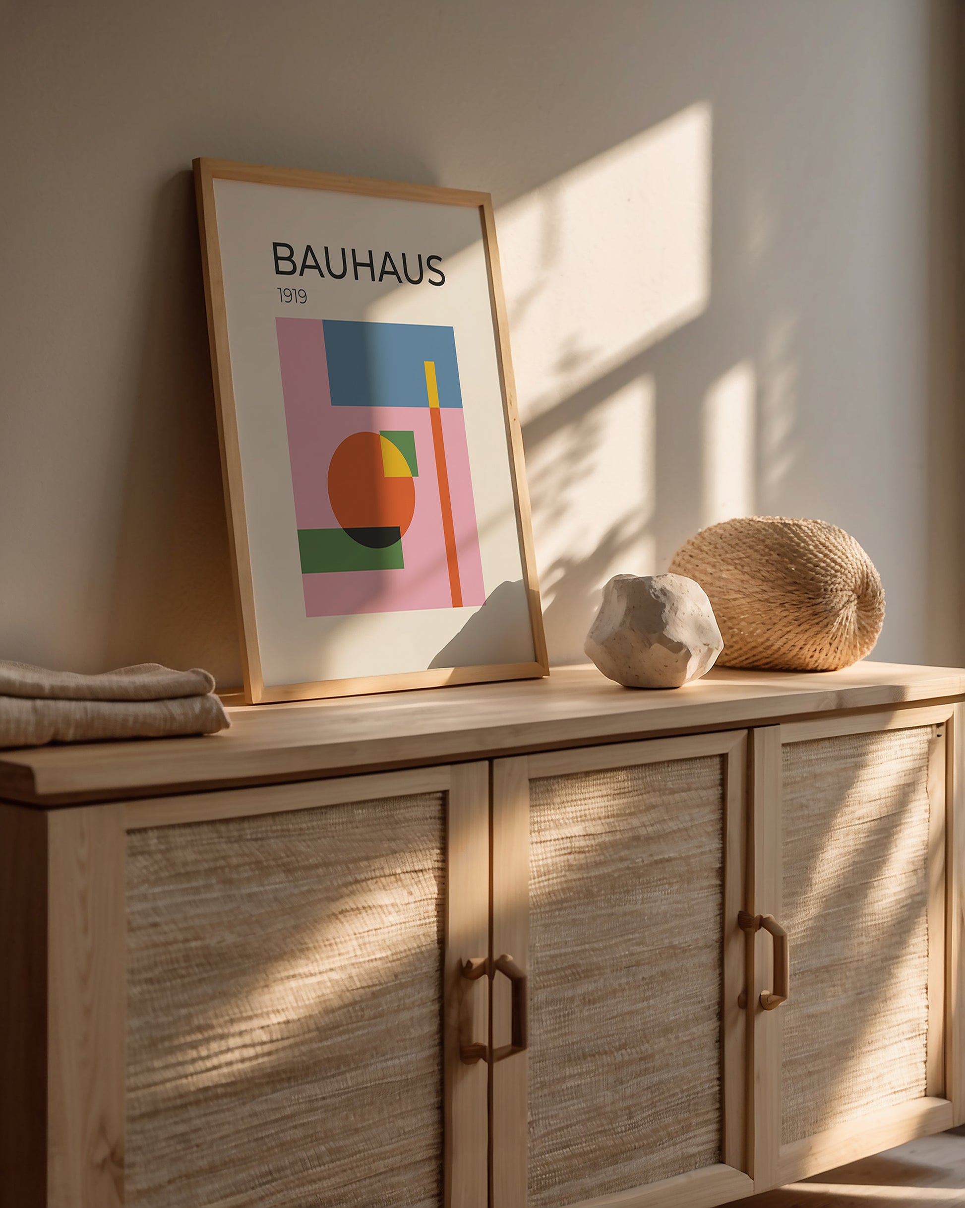 Bauhaus art print framed on a cabinet, showcasing modern abstract design with circles and geometric shapes.