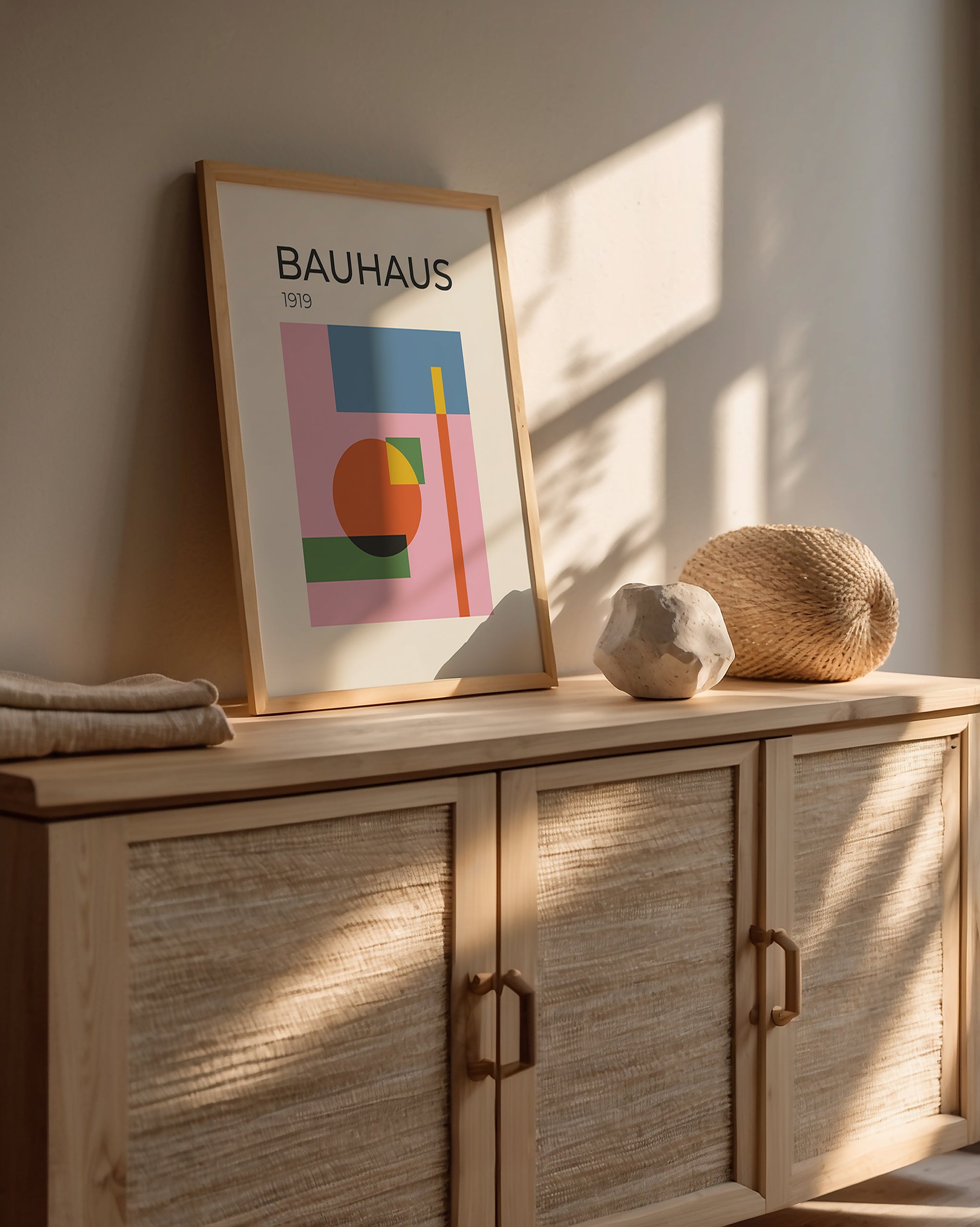 Bauhaus art print framed on a cabinet, showcasing modern abstract design with circles and geometric shapes.