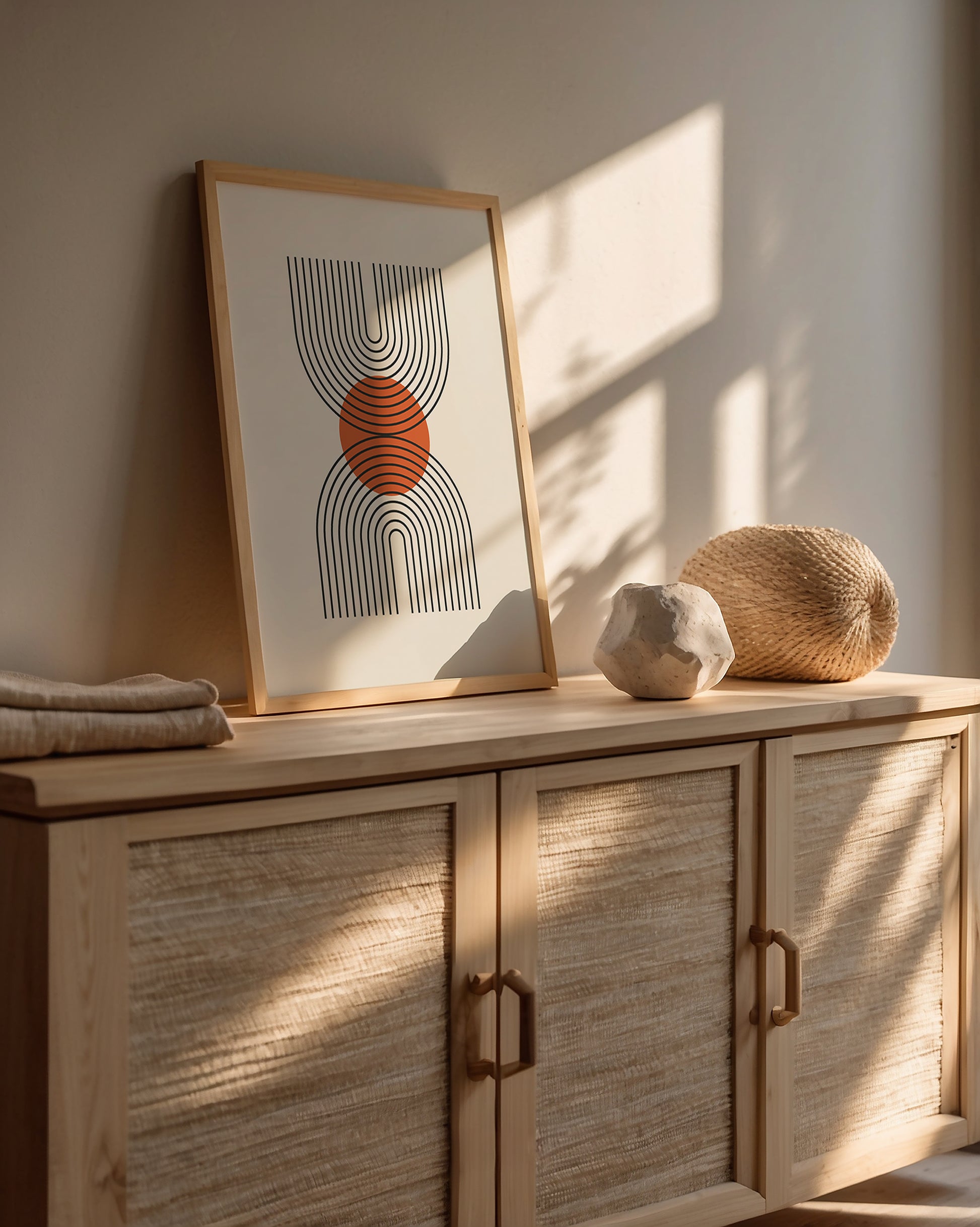 Bauhaus wall art print featuring geometric U-shaped lines with a terracotta sun on a stylish wooden sideboard.
