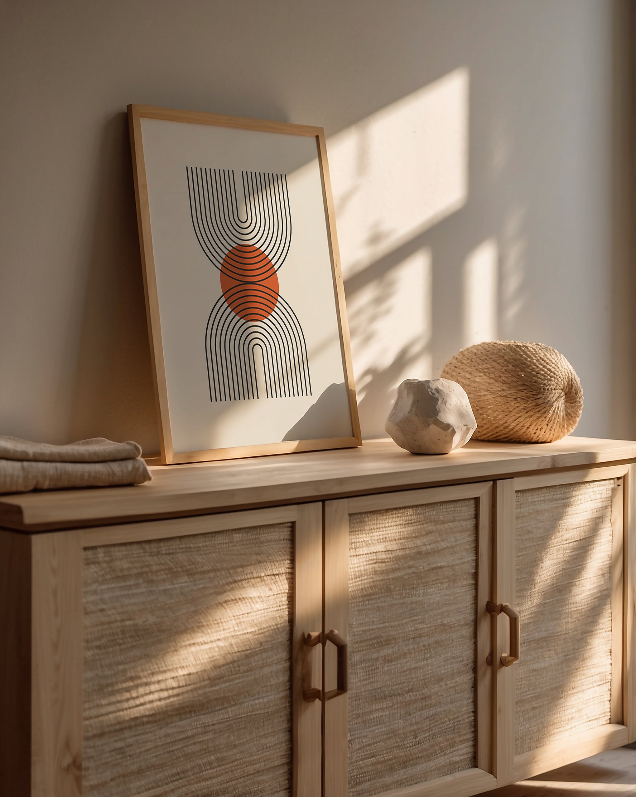 Bauhaus wall art print featuring geometric U-shaped lines with a terracotta sun on a stylish wooden sideboard.