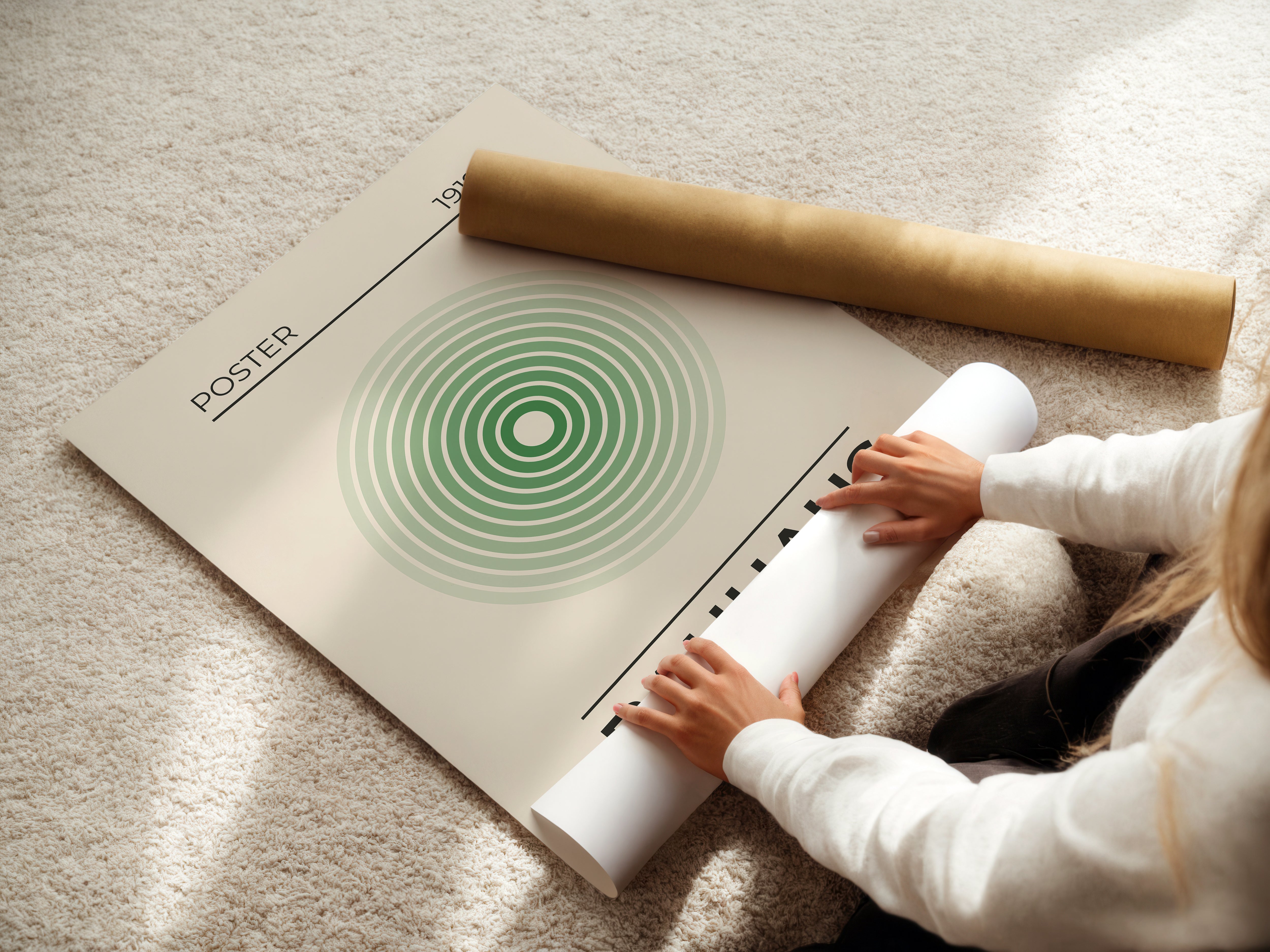 Person unrolling a Bauhaus-inspired minimalist wall art print with concentric green circles on a cozy carpet.