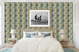 Bedroom with Aloha Boards coastal wallpaper featuring surfboards in tropical motifs, framed art, and mid-century modern decor.
