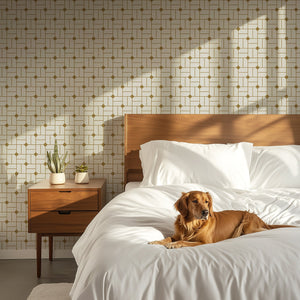 Art Deco geometric wallpaper in gold and white behind a bed with a sleeping dog, creating a retro and sophisticated bedroom ambiance.