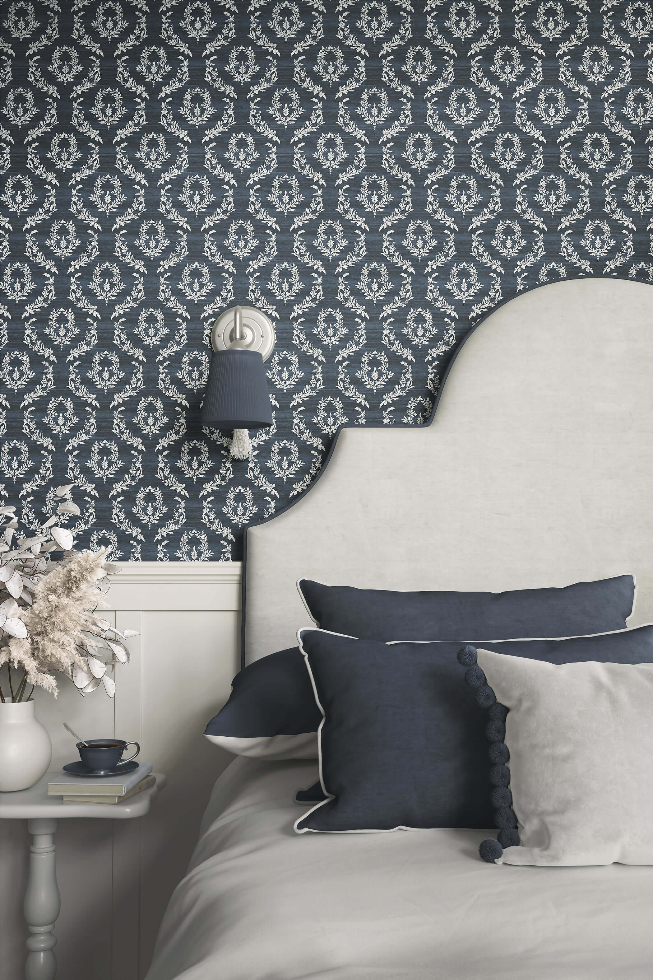 Elegant bedroom with Midnight Laurel wallpaper featuring white laurel wreaths on dark blue, complementing traditional decor.