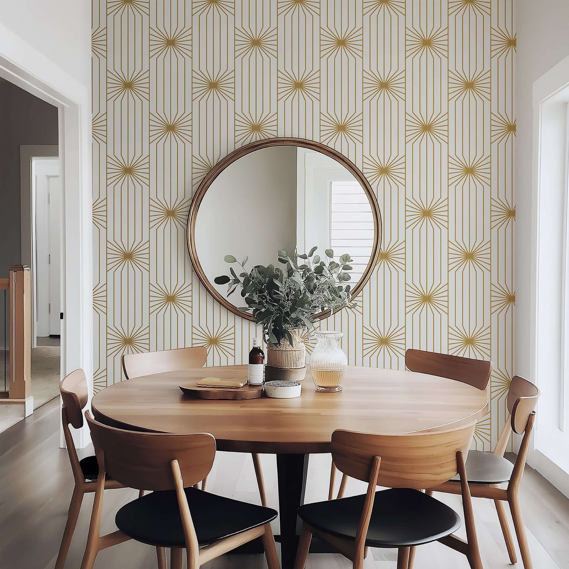 Art Deco wallpaper with gold geometric sunburst lines on ivory background in modern dining room with round mirror and wooden furniture.