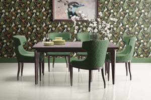 Art deco dining room with Mystical Garden Elegance wallpaper featuring peacocks and floral design, green chairs and dark wood table.