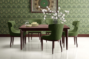 Art Deco dining room with Emerald Luxe Palm Deco wallpaper, green chairs, and a wooden table accentuating vintage style.