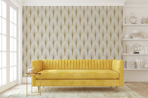 Art Deco geometric wallpaper with gold fan-shaped arches on ivory background, styled in retro living room with yellow couch and white accents.