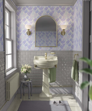 Lavender and blue coral coastal wallpaper in a vintage-style bathroom with white sink and mirrored lighting.