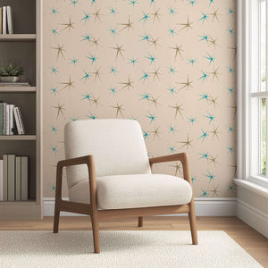 Mid-century modern wallpaper with teal and taupe starbursts on cream background, featuring retro geometric design in a cozy room.