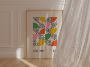 Geometric Bloom Bauhaus wall art print featuring layered semicircles in vibrant colors on a wooden floor.